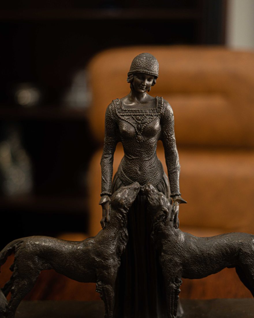 Escultura de bronze de uma mulher com dois cães, em uma das salas do escritório